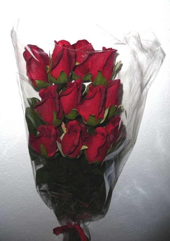 showing the Dozen silk Single Stemmed Red Roses up close, as supplied in a clear polybag tied with a Red Ribbon.