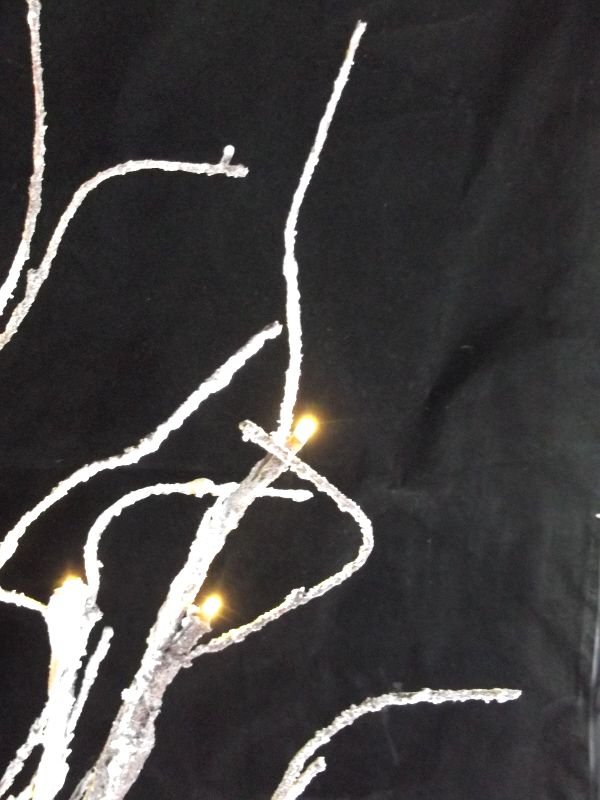 showing Artificial LED Snowy Twig Tree with base and wire - Close up of LED Against Black Background