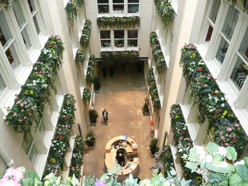 JustArtificial.co.uk supplied this high standard refurbished Office's Reception Atrium in Manchester with colourful Silk Trailing Flowers and Ivy, along with floor standing Artificial Plants and Trees on the Ground Floor creating a wonderful impact and great focal points of interest