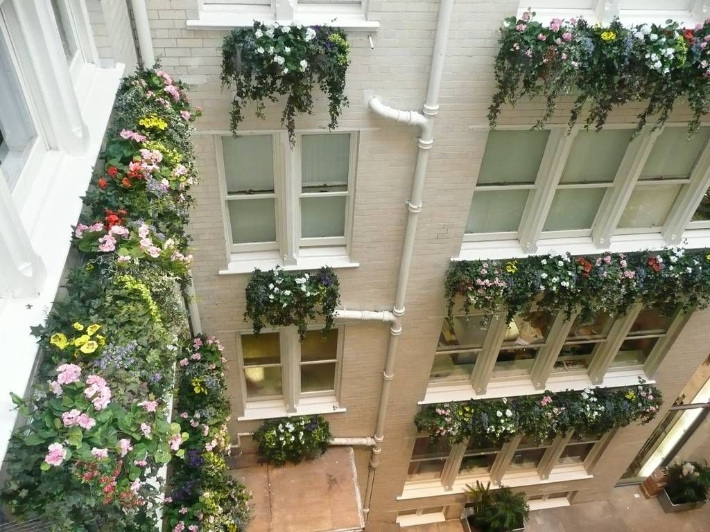 JustArtificial.co.uk supplied this high standard refurbished Office's Reception Atrium in Manchester with colourful Silk Trailing Flowers and Ivy, along with floor standing Artificial Plants and Trees on the Ground Floor creating a wonderful impact and great focal points of interest